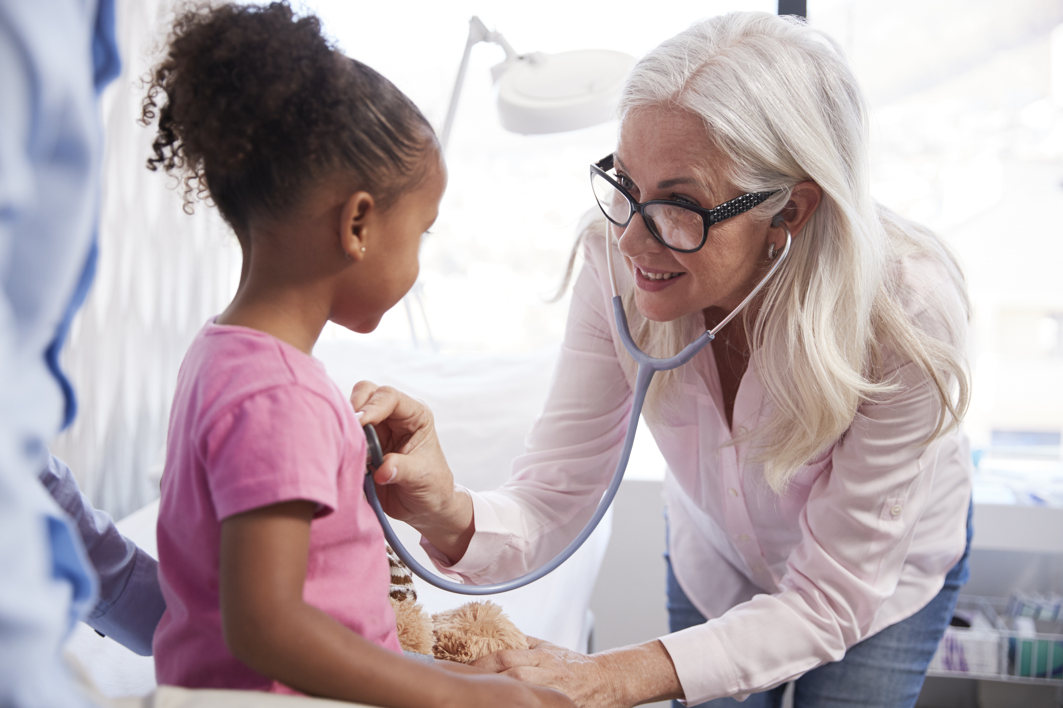 Father With Daughter In Consultation With Doctor In Office
